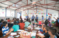 Members of the OSEMAP giving the children an invitation to the concert held at the shelter of the La Industria farm, Escuintla.