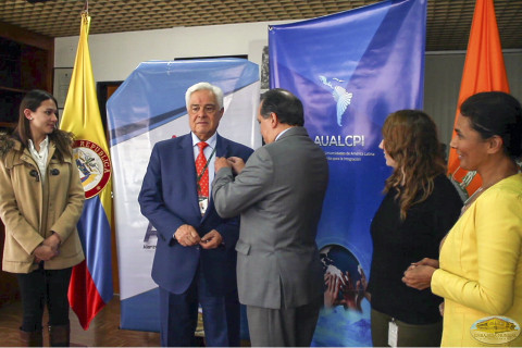 Coordinador nacional de la EMAP colocando el pin dela ALIUP, como acto protocolario como nuevo miembro de la Alianza, al Dr. Germán Anzola, director de ambas instituciones. Acto protocolario.